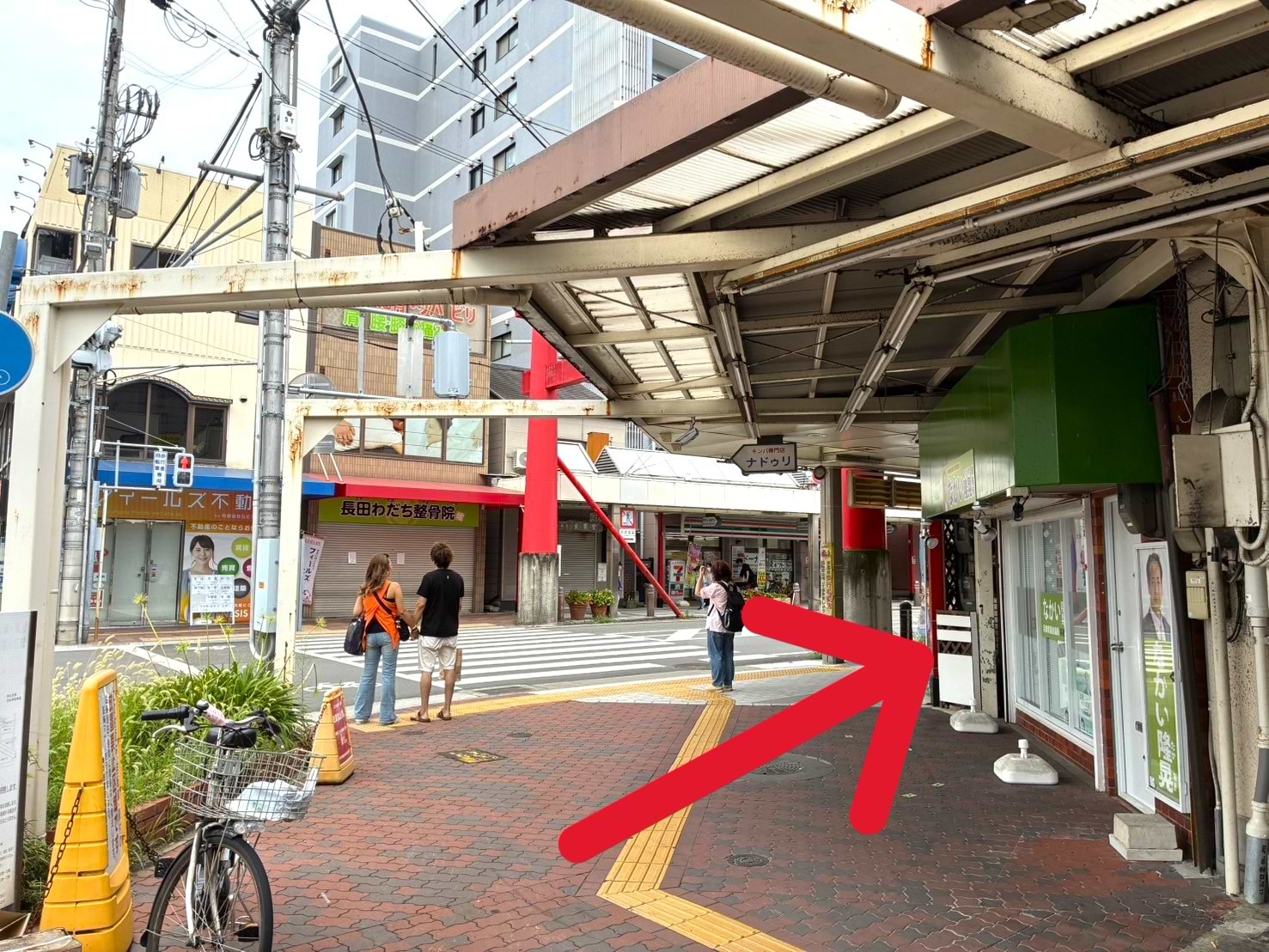 階段を上がるとすぐ右手に商店街が見えますので、信号は渡らずに右折します