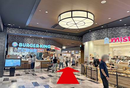 左手にあるバーガーキングとミスタードーナツの間の通路を進みます。<br />
