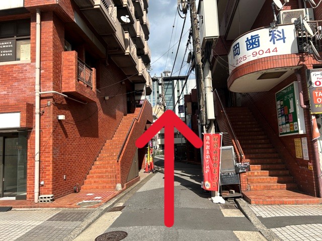 赤レンガ風のビル2棟の間の道を150ｍほど直進します