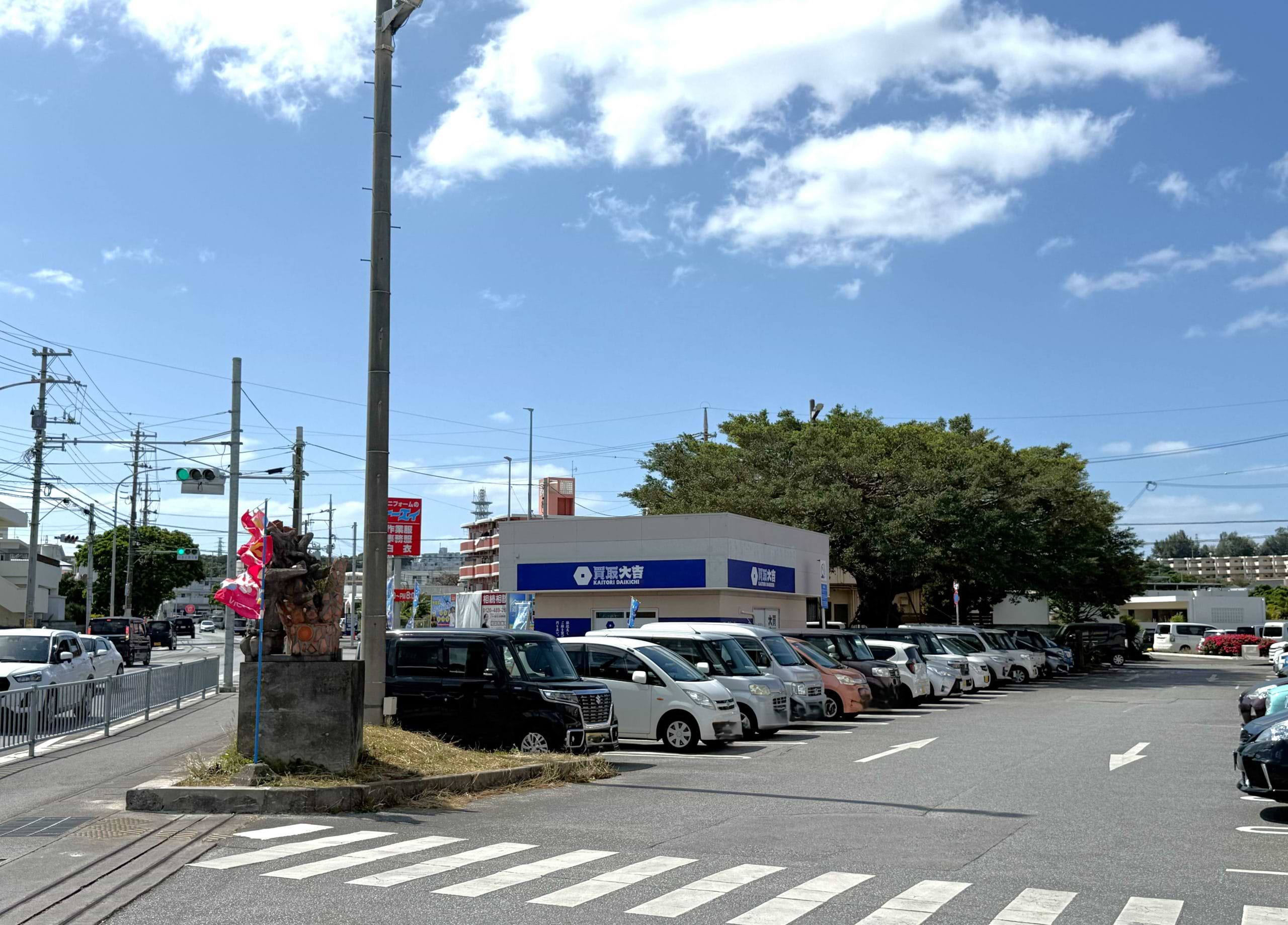 駐車場敷地内左手に白い建物の当店が見えてきます
