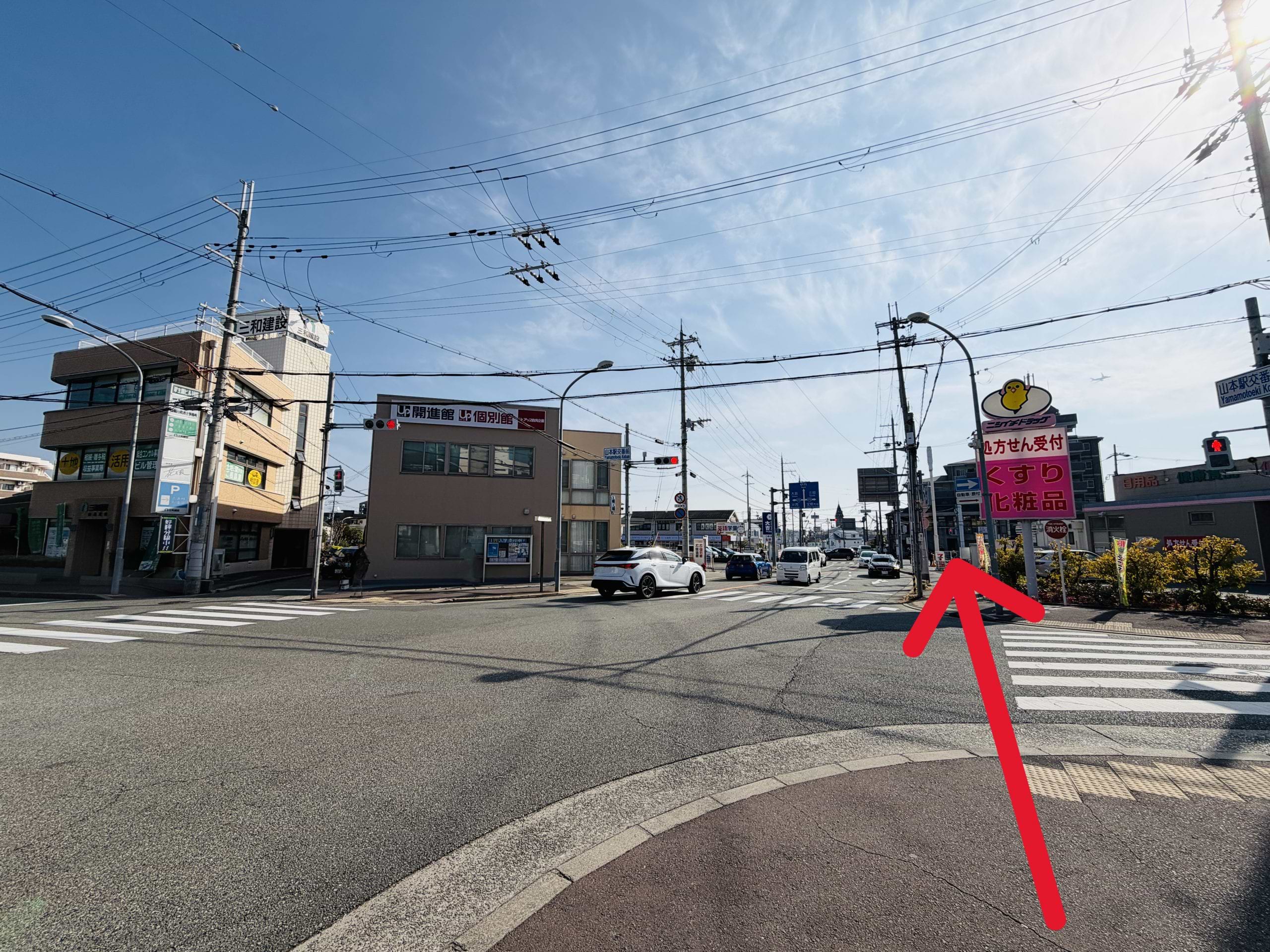 山本駅交番前交差点を横断し（右手側にニシイチドラッグさま）、山本交番南交差点へ向かってさらに直進します