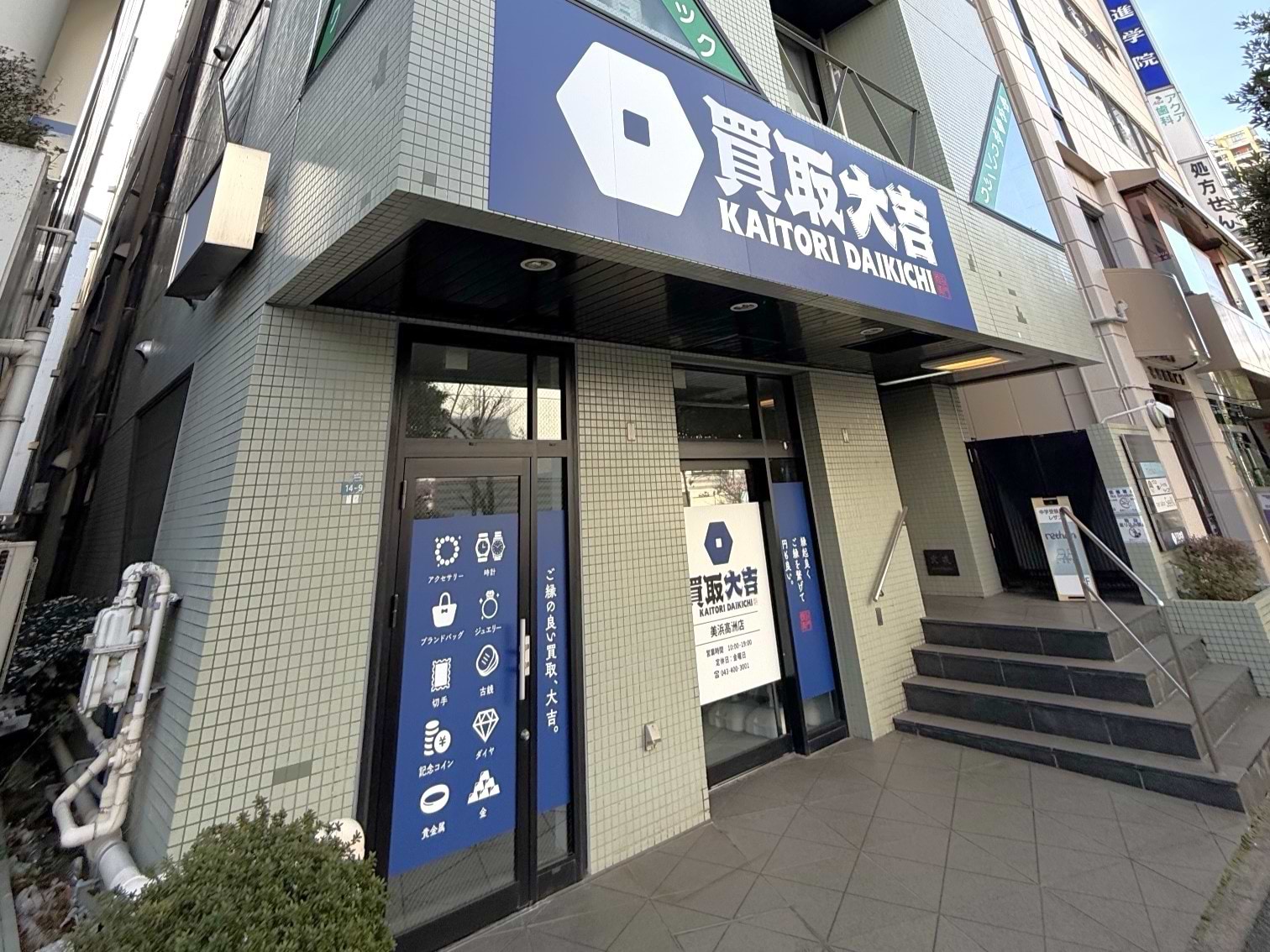 左手に薄い緑色のビルがあり、1階が当店でございます