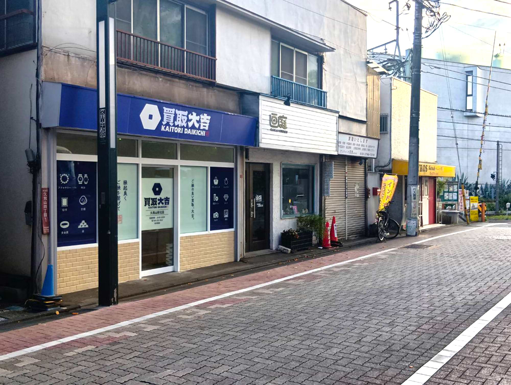 向かい側に当店がございます
