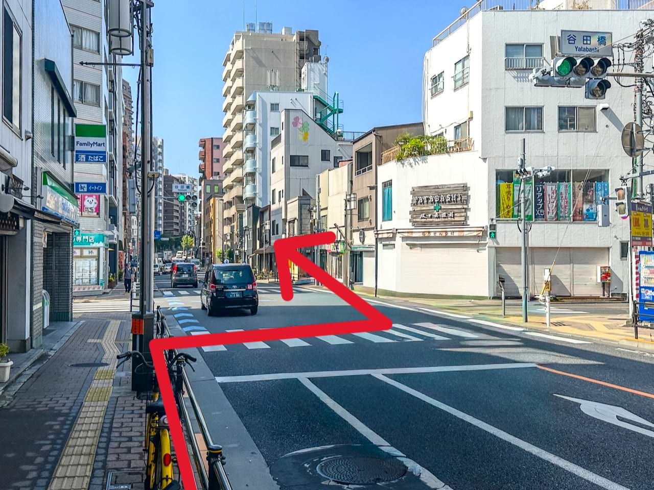 左手にあるファミリーマート 田端一丁目店様を目印に、谷田橋交差点の横断歩道を斜め右前方向へ渡り、そのまま直進します