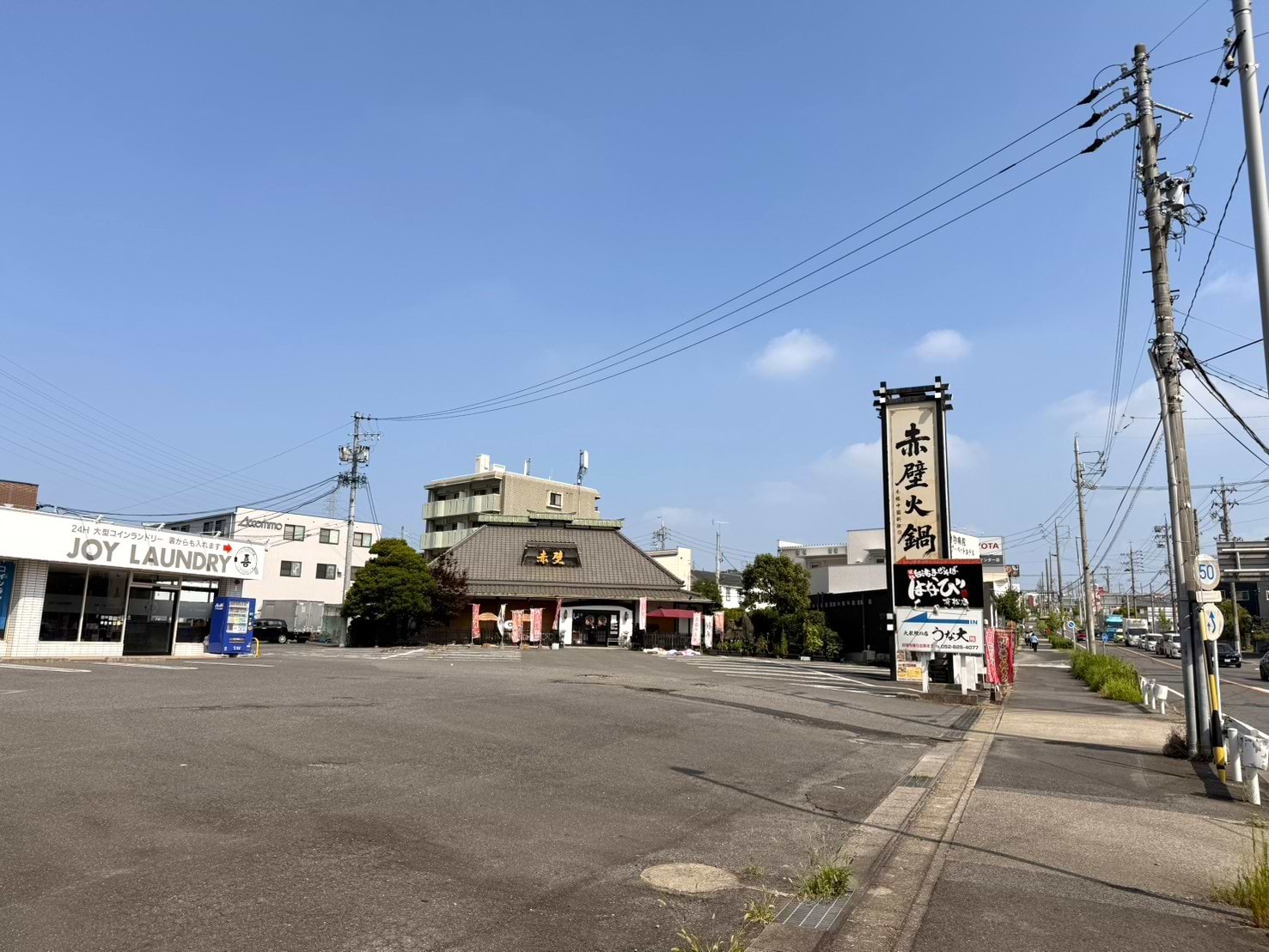 左折後すぐ、左手に「JOY LAUNDRY」（コインランドリー）があり、その隣に当店がございます。