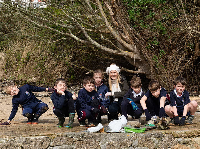 Children collecting ocean plastics on a beach for the Cleaner Ocean Project