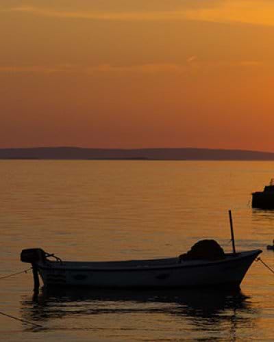 Fishing boats in water near Starigrad in Croatia at sunset