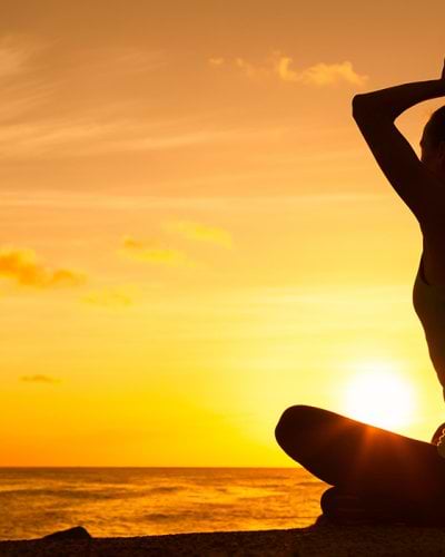 Girl meditating at sunset