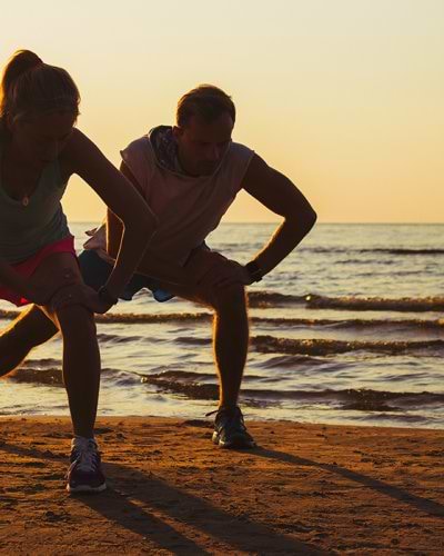 two people exercising at the beach