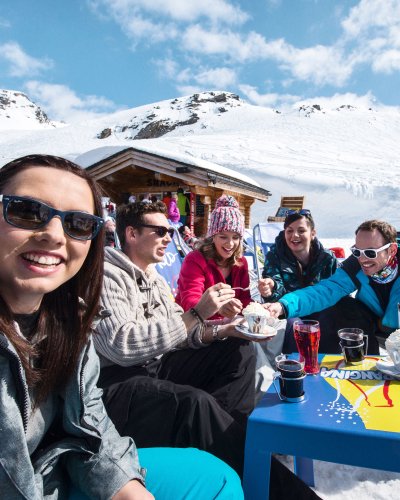 group of friends enjoying a drink in a cafe on a ski holiday