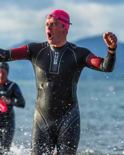 triathlete emerging from water after completing swim