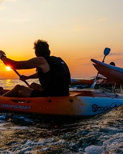 people kayaking at sunset