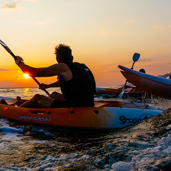 people kayaking at sunset