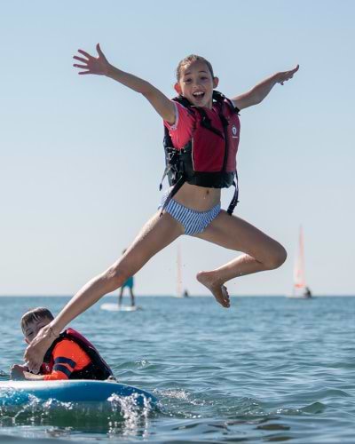 girl jumping off paddle board