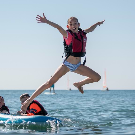 girl jumping off paddle board
