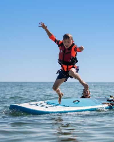 boy jumping from paddle board