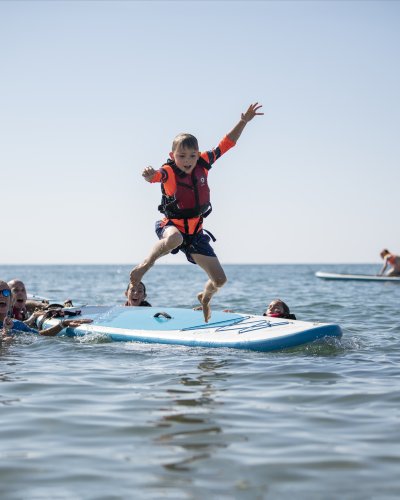 boy jumping from paddle  board