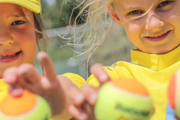 2 girls holding tennis balls