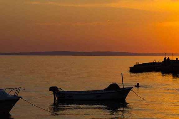 Fishing boats in water near Starigrad in Croatia at sunset