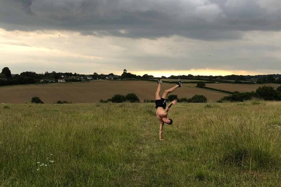 Archie doing a handstand in a field