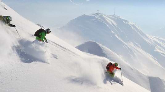 Skiers and Snowboard on a powder run