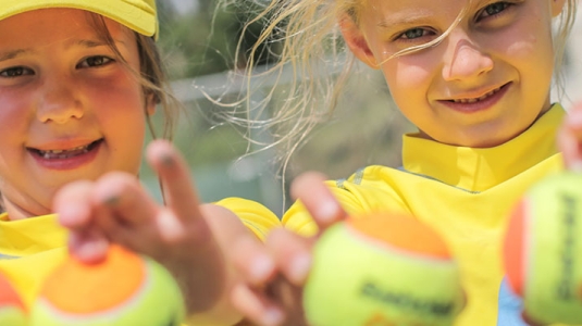 2 girls holding tennis balls