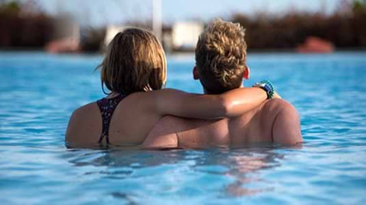 couple with arms around each other in a swimming pool