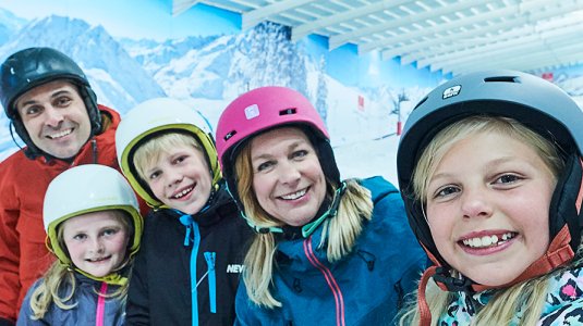 family skiing in the snow centre