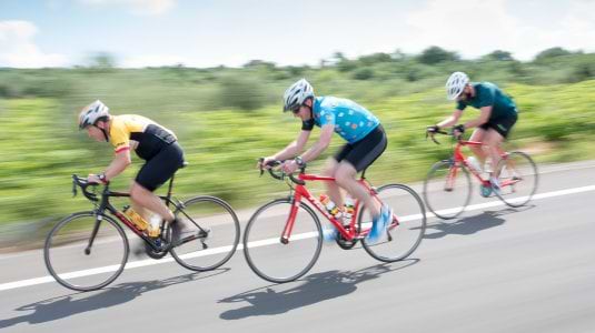 Three people road cycling