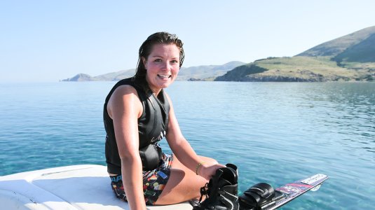 Girl on back of boat after water skiing