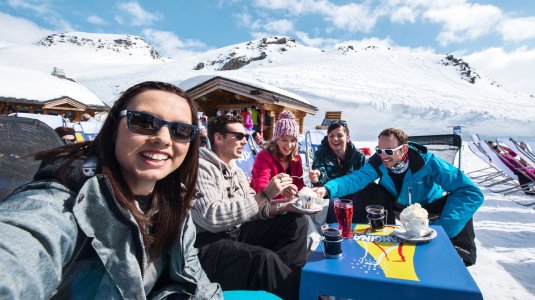 group of friends enjoying a drink in a cafe on a ski holiday