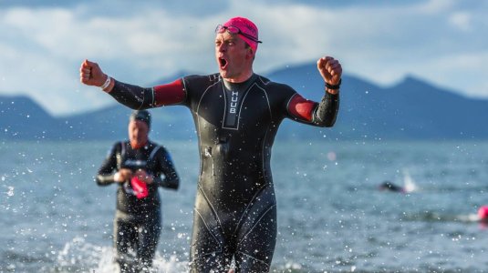 triathlete emerging from water after completing swim