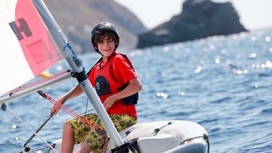 teenage boy sailing a dinghy in Greece