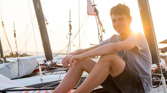 teenage boy sitting on a boat