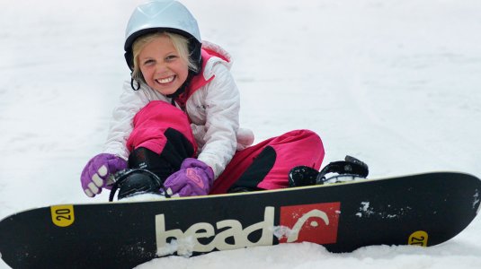 A girl sat down with a snowboard