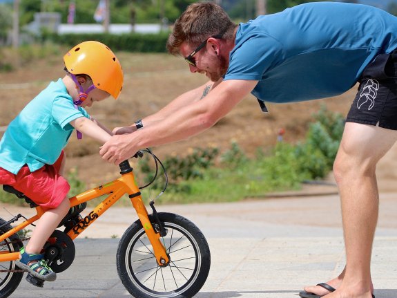 neilson staff teaching a child to ride a bike