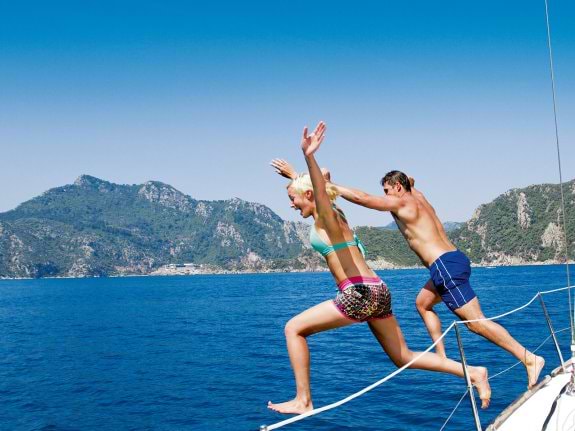 couple jumping from a yacht