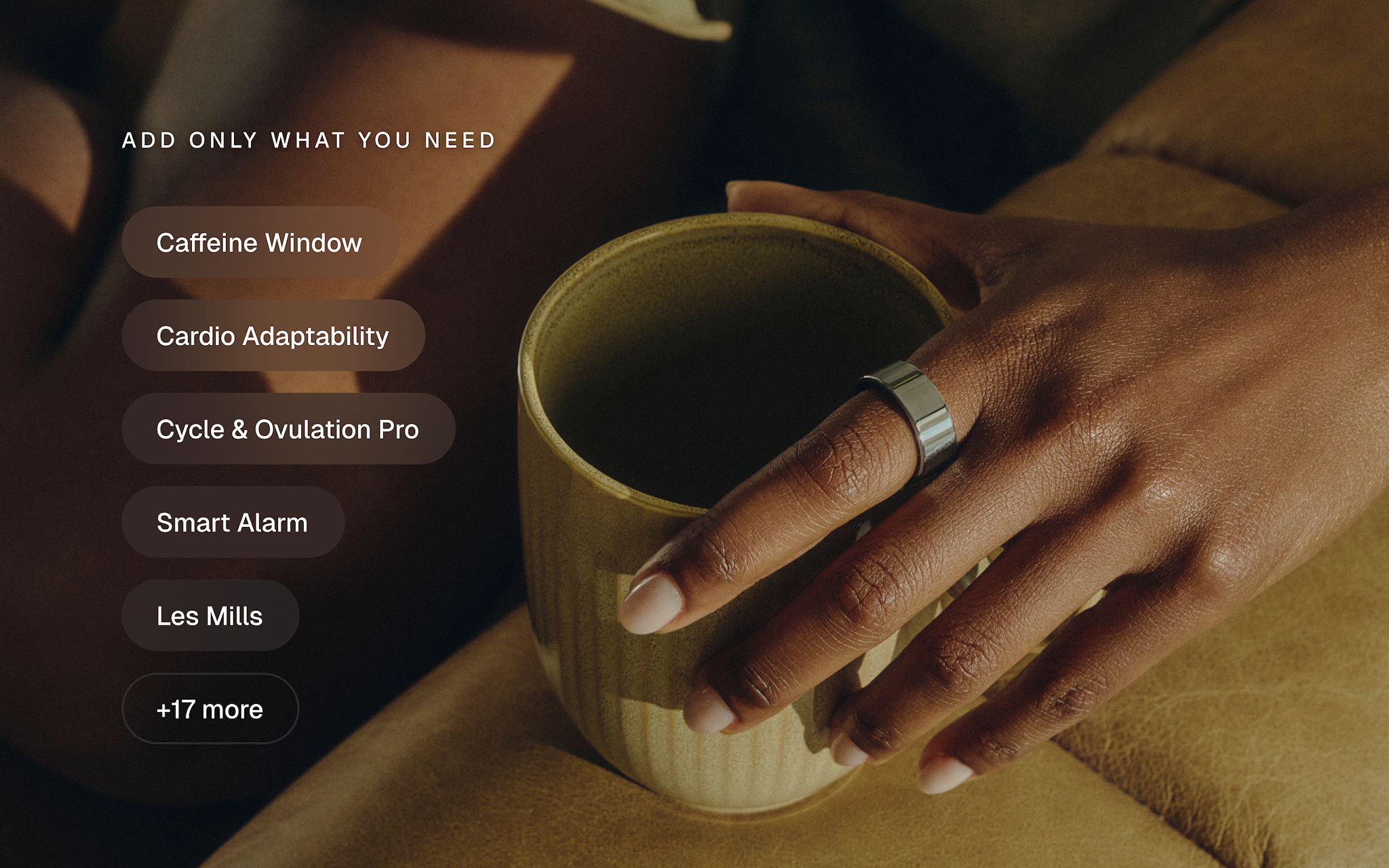 A hand wearing the Ultrahuman Ring AIR holding a warm drink