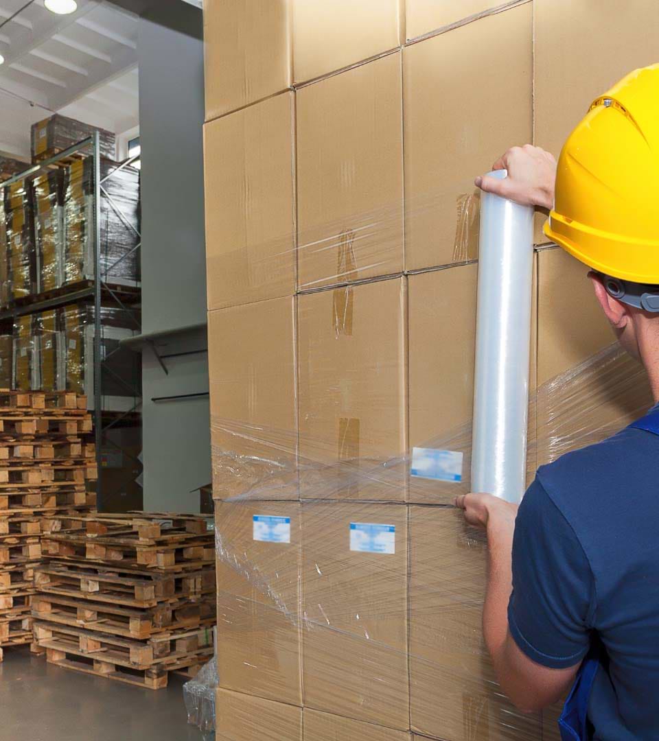 person-wrapping-pallet-of-boxes-with-stretch-wrap-film