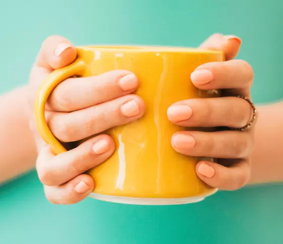person-holding-yellow-mug