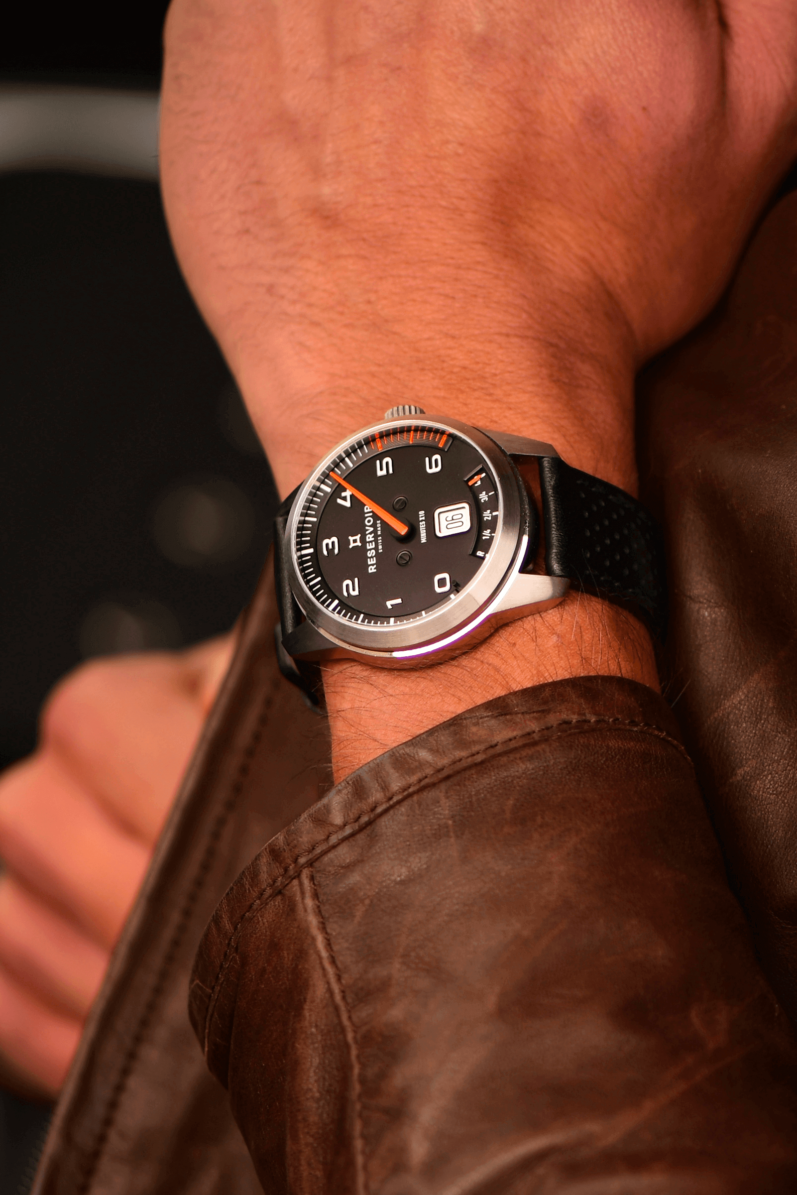 Media editorial of luxury RESERVOIR watch in dark brown, light salmon pink, and light greyish brown.