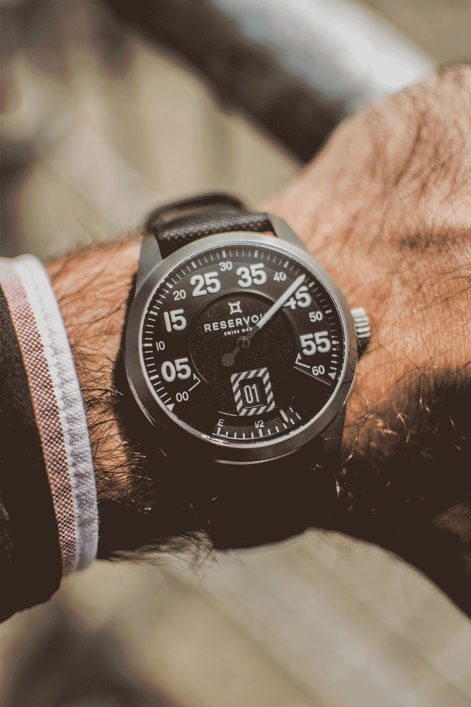 Airfight ライトトープ、ダークブラウン、ミディアムブラウンの背景にジェットを配した腕時計。