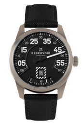 Airfight watch with jet against very dark grey, light beige, and light grey background.