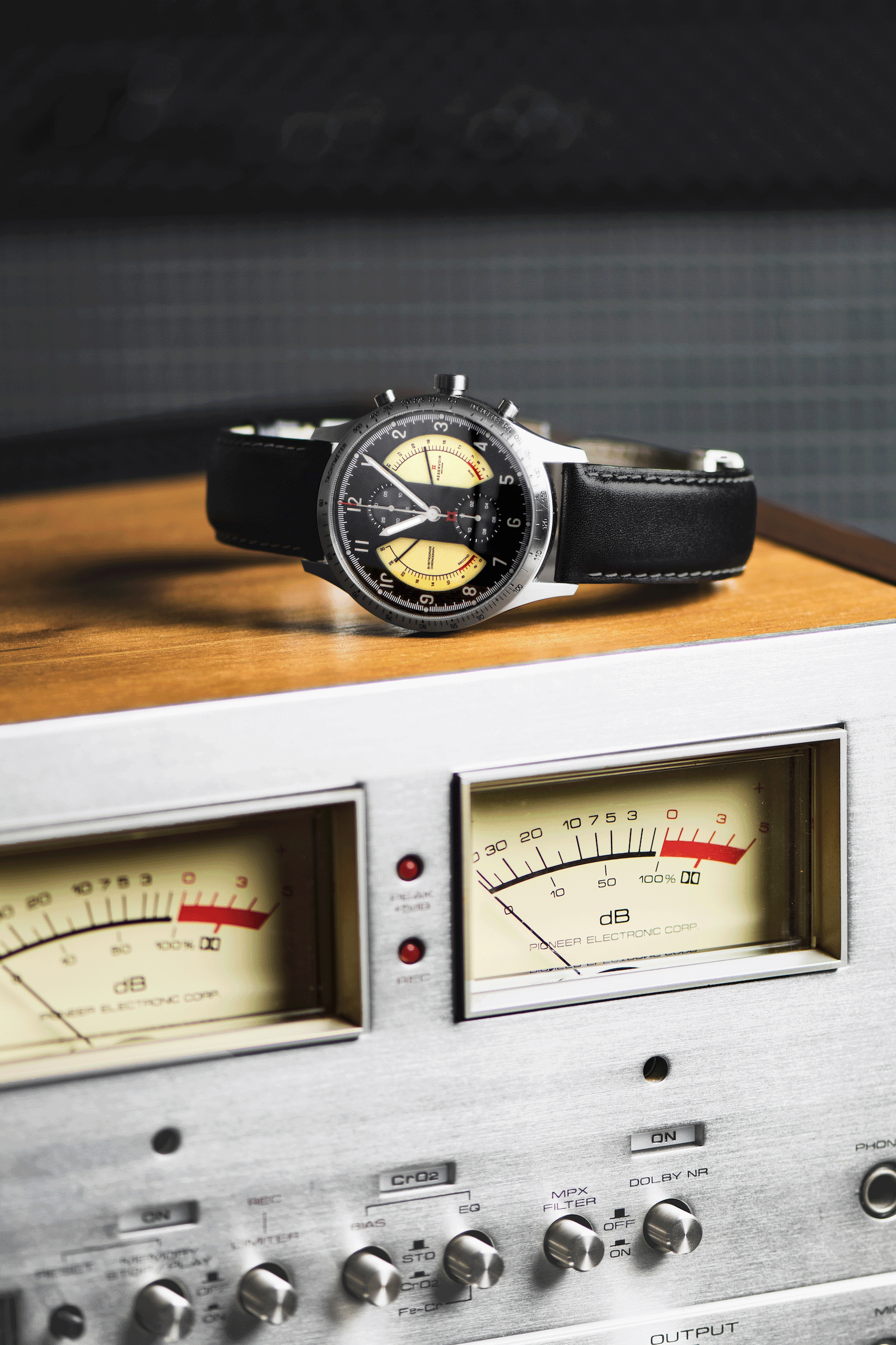 Dark brown watch with vu meter, light beige chronograph, and light grey music dials.