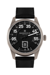 Silver case watch with black textured strap, date display, and power reserve indicator.