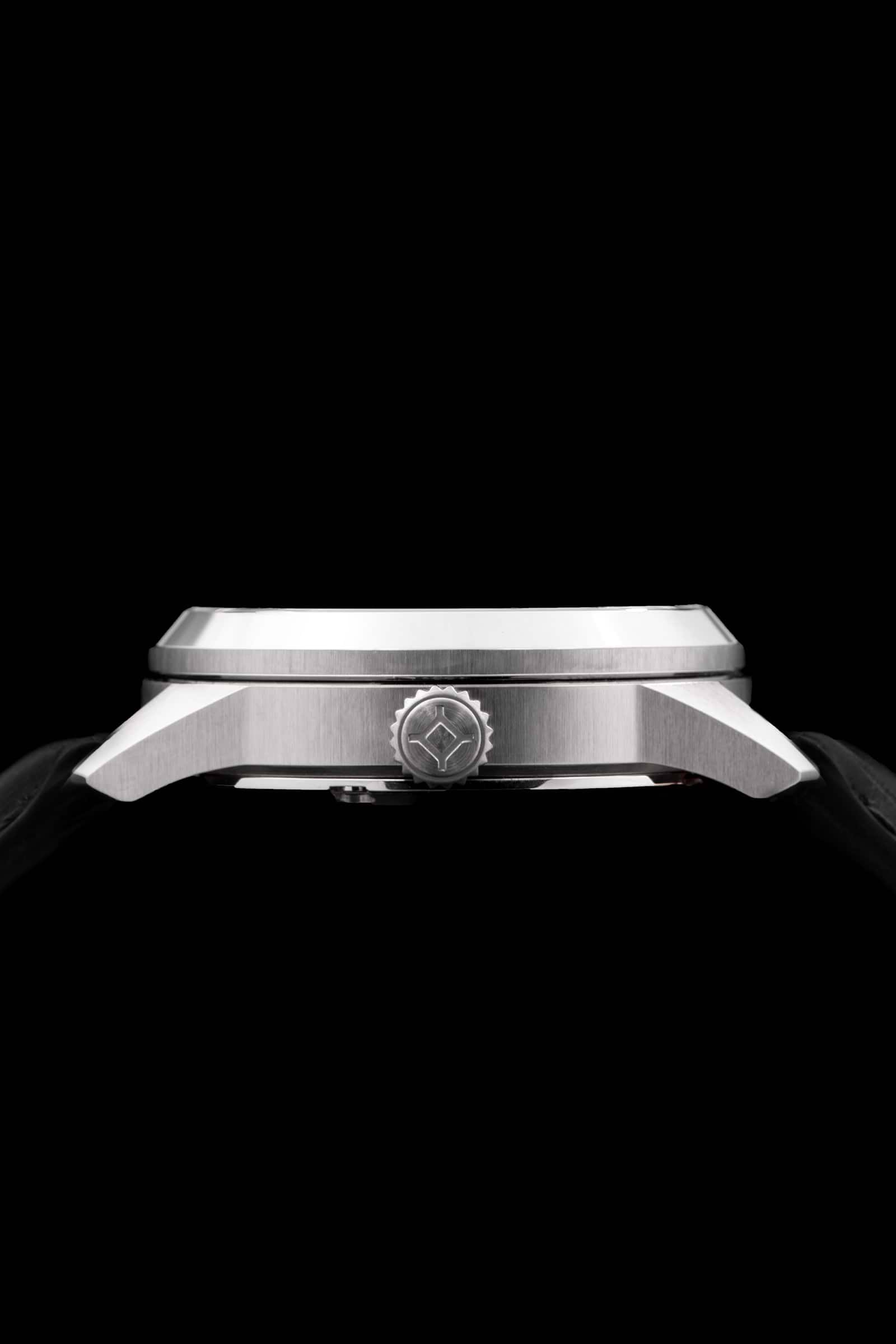 Gros plan sur le côté d'une montre-bracelet voir avec acier inoxydable boîtier, couronne embossée et cuir noir bracelet.