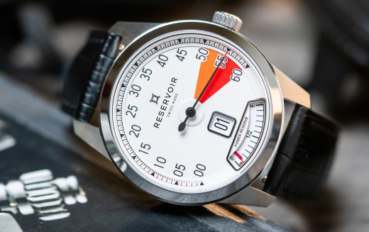 Wristwatch with black leather strap, silver bezel, white dial, Arabic numerals, and "RESERVOIR" branding.