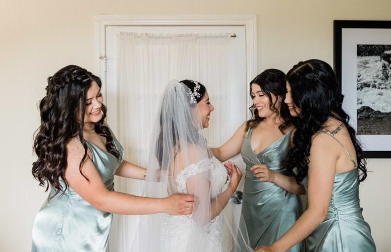 Bridesmaids preparing bride for wedding day in mint green dresses - San Clemente Shore by Wedgewood Weddings