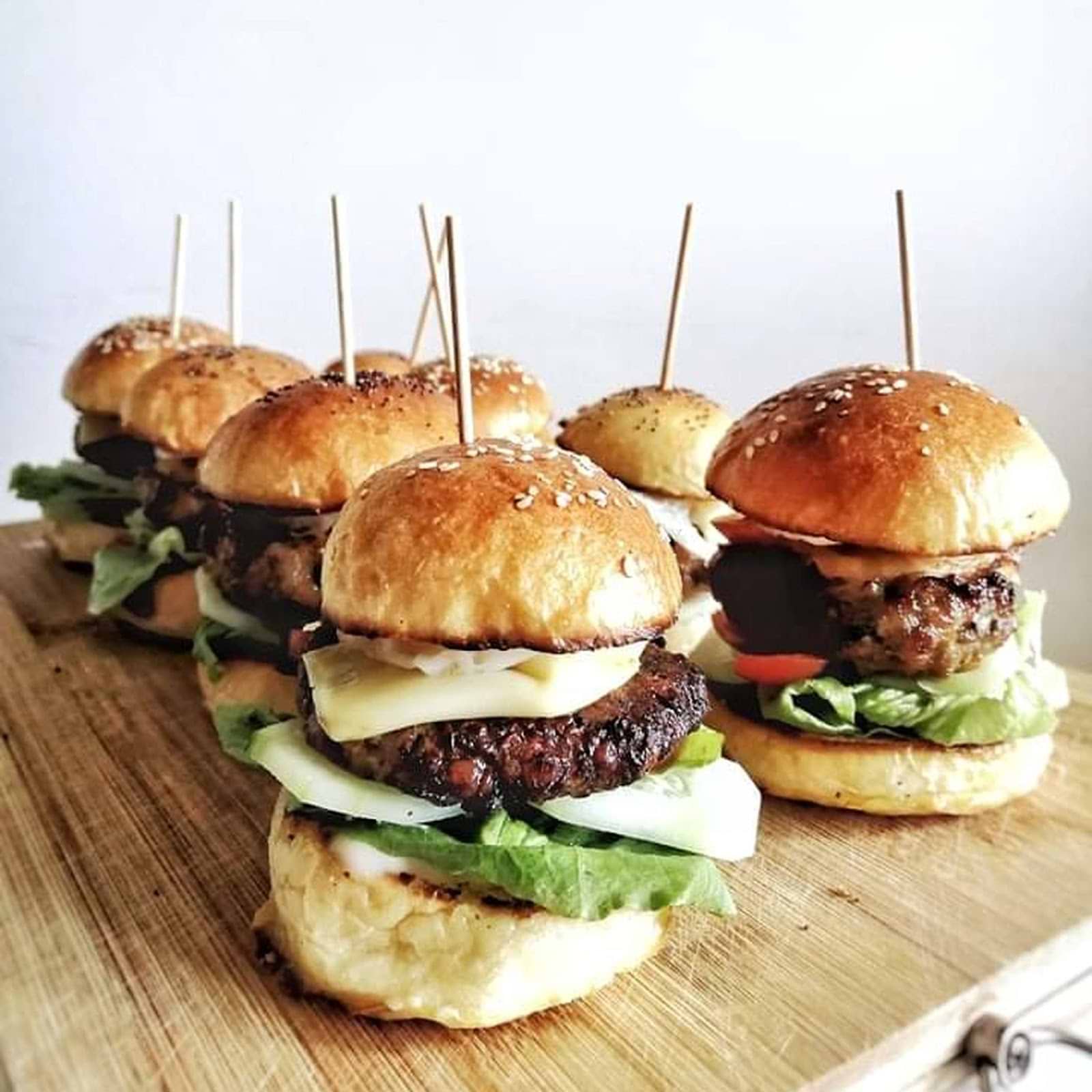 sliders being display in a wooden cutting board