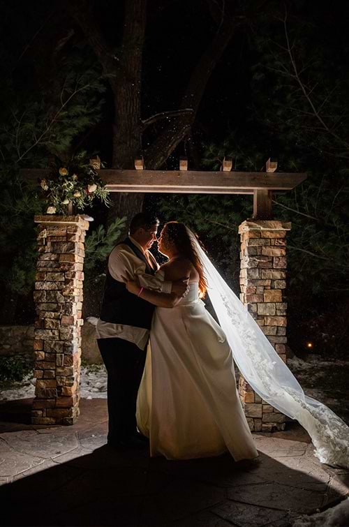 Bride and groom at night in snow flurry - Boulder Creek by Wedgewood Weddings